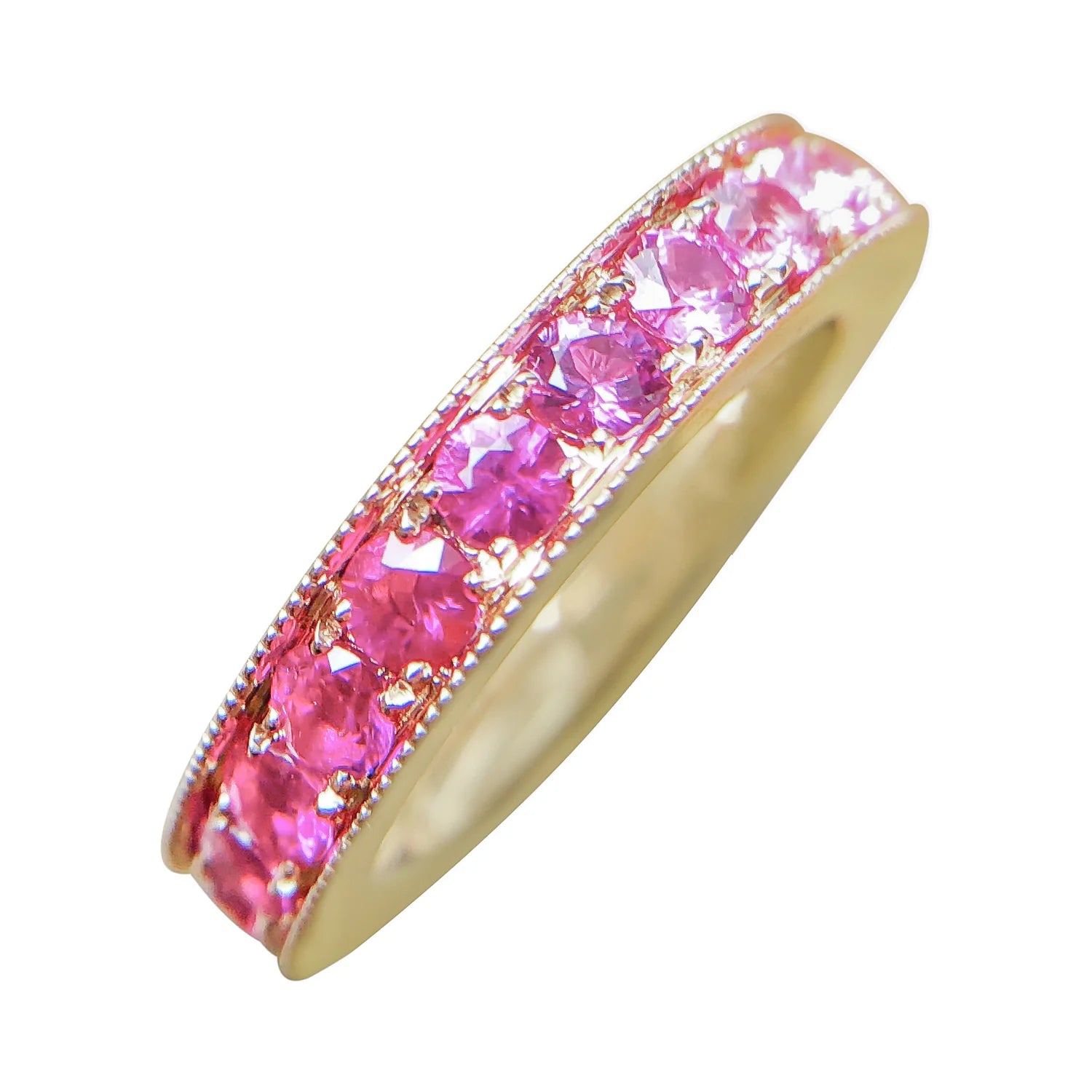 Gold ring with pink gemstones on a white background