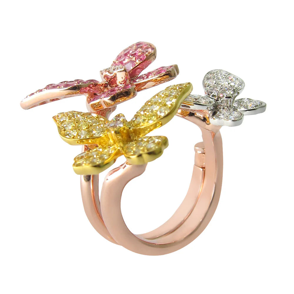Ring with butterfly-shaped gemstones in pink, yellow, and silver on a white background