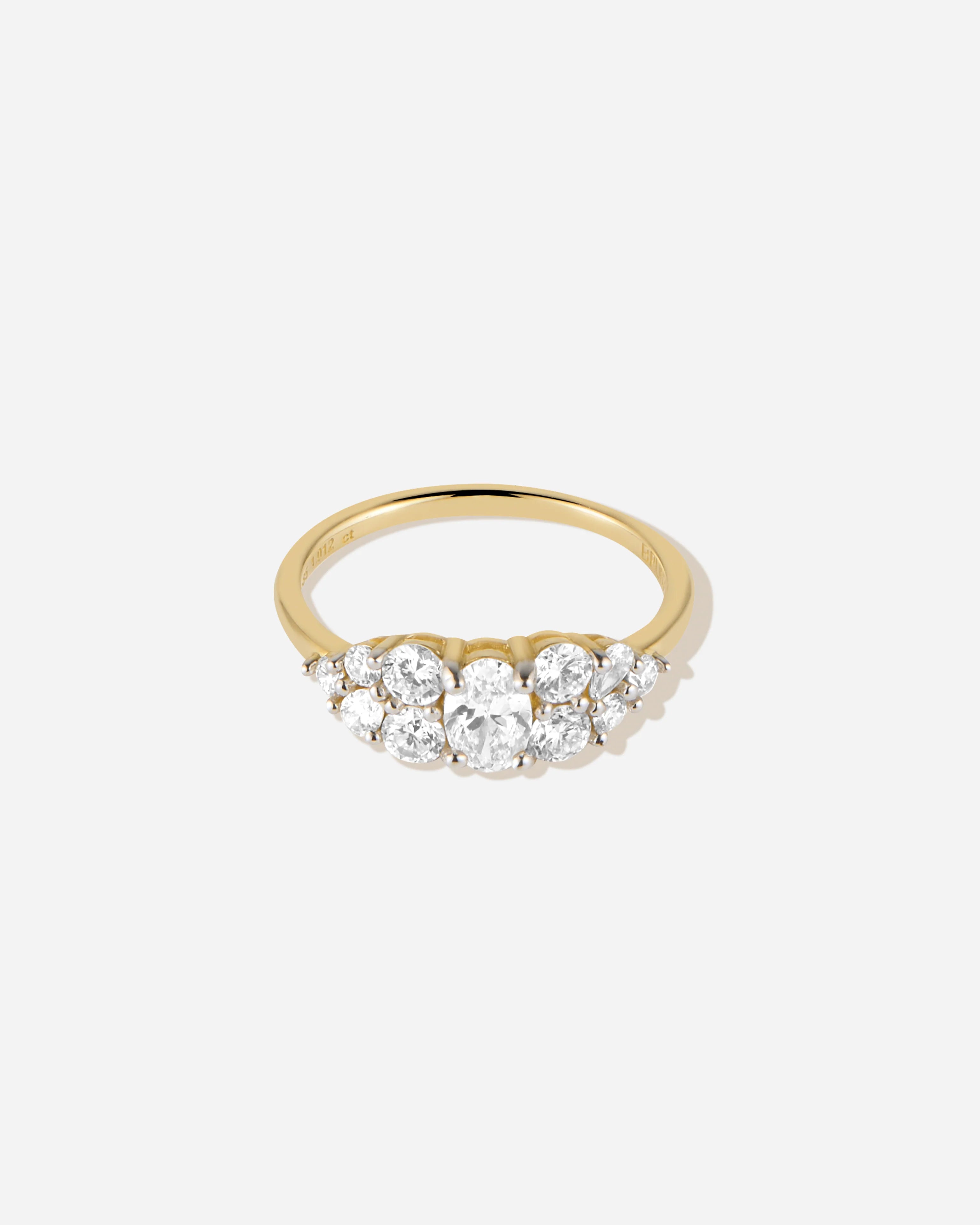 Gold ring with three clear gemstones on a white background