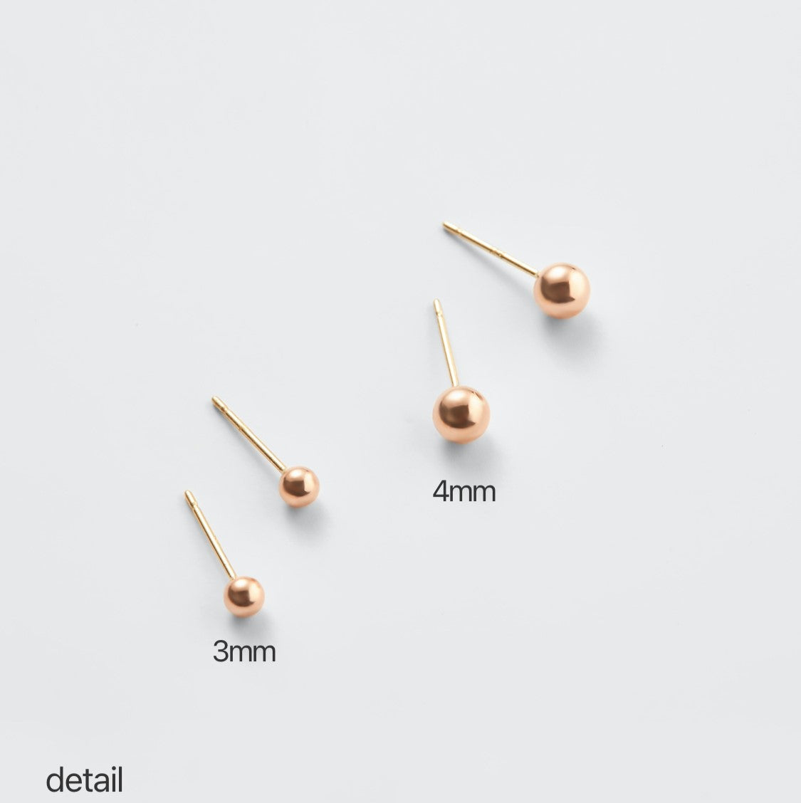 Classic round gold stud earrings displayed on jewelry stand