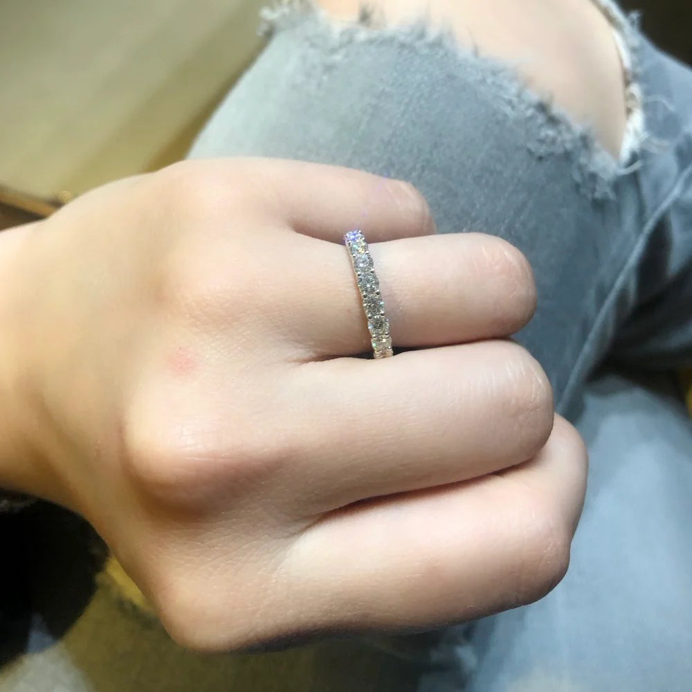 Close-up of a hand wearing a silver ring with a blurred background