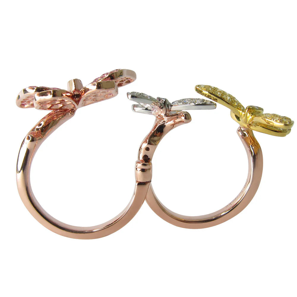 Two gold rings with bow designs on a white background