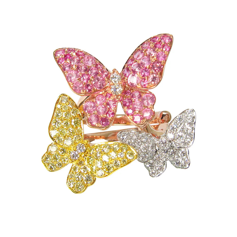 Three butterfly-shaped rings in pink, yellow, and silver on a white background
