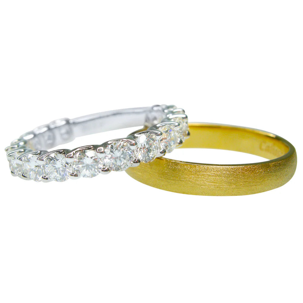 Two diamond rings, one silver and one gold, on a white background