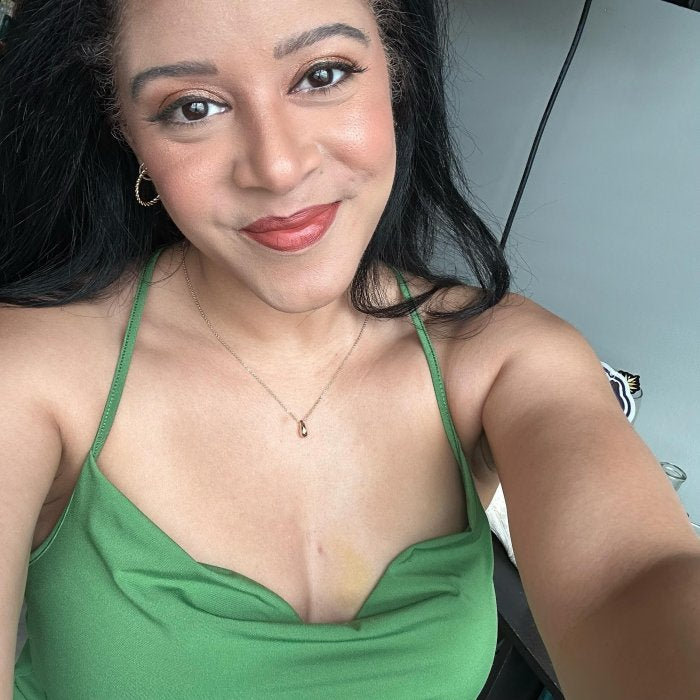 Woman wearing a green top with a neutral background