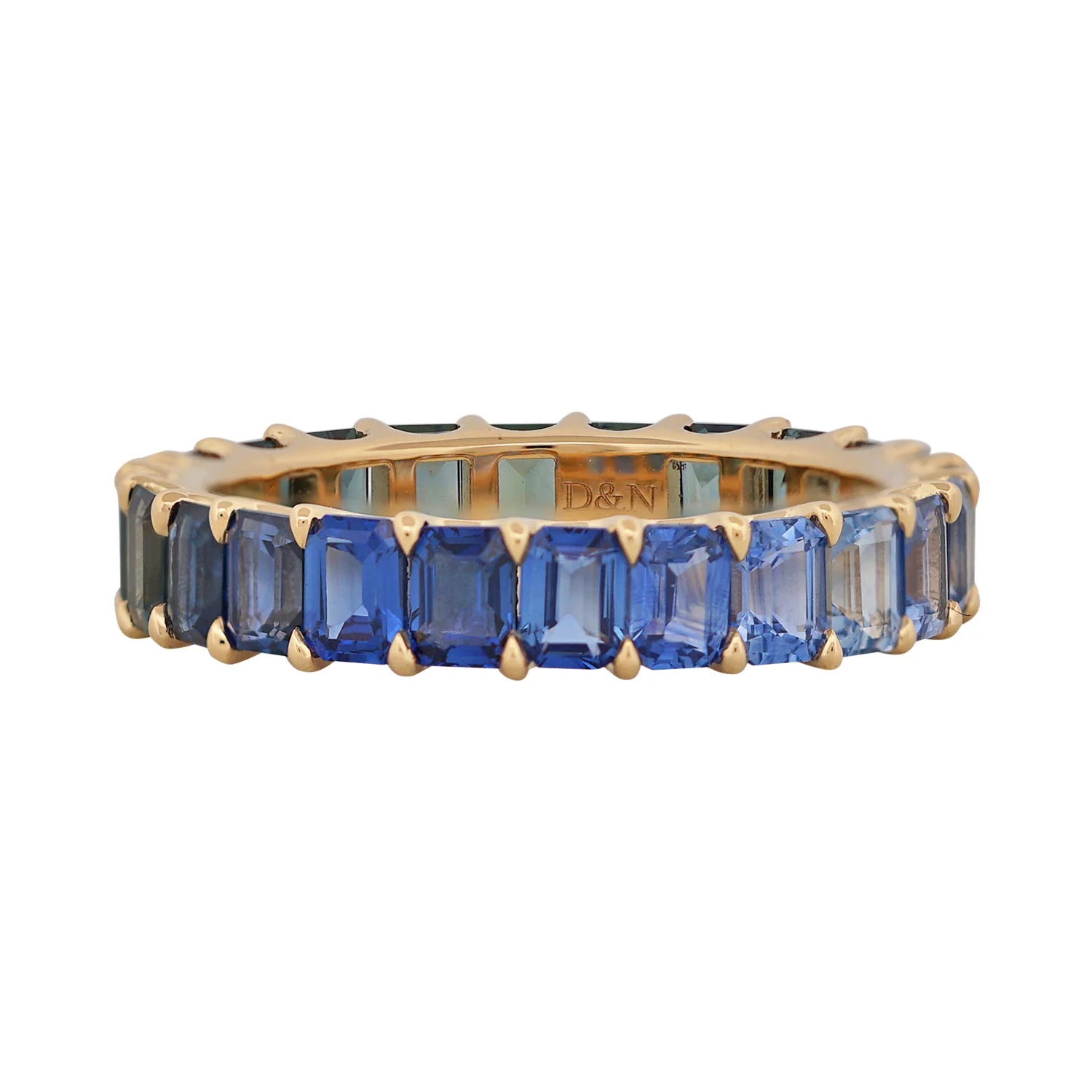 Gold ring with blue gemstones on a white background