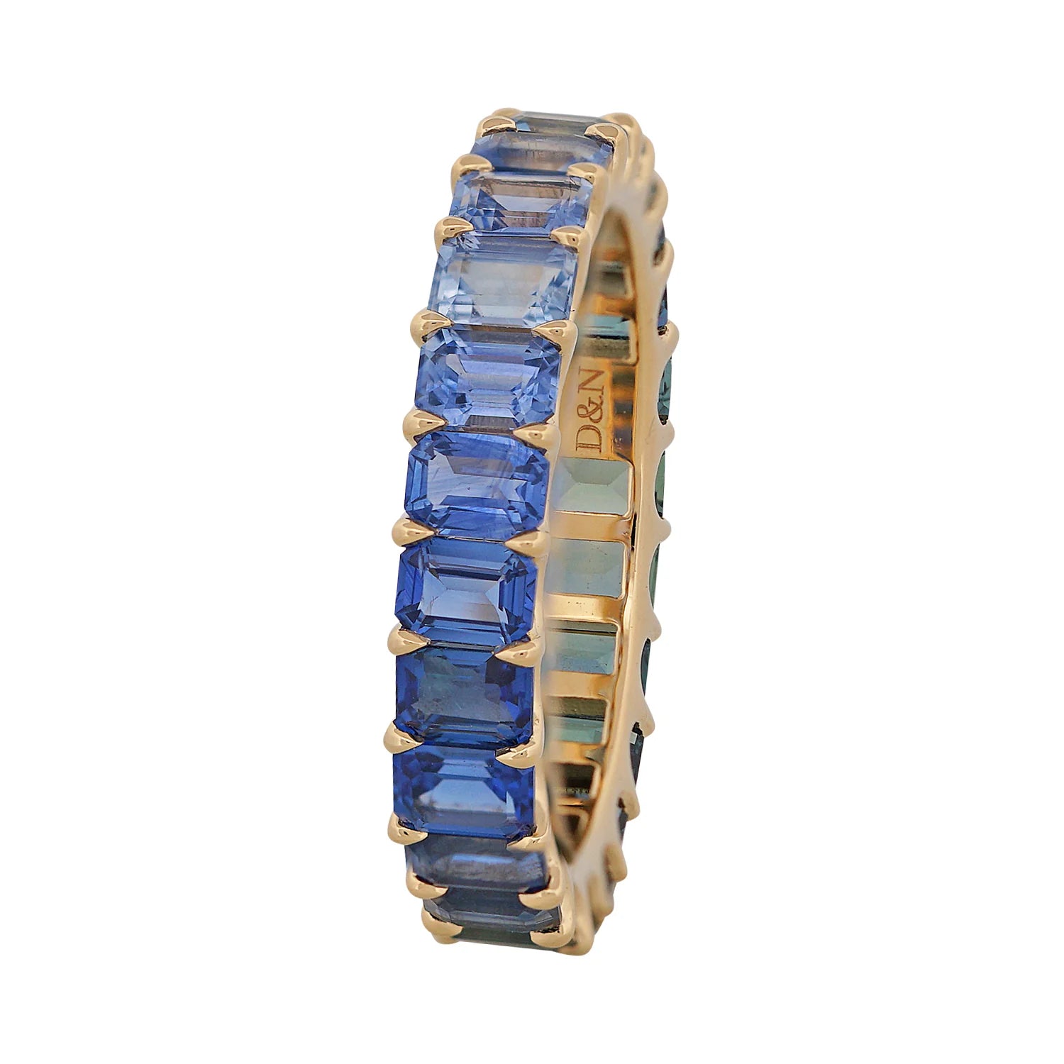 Gold ring with blue gemstones on a white background