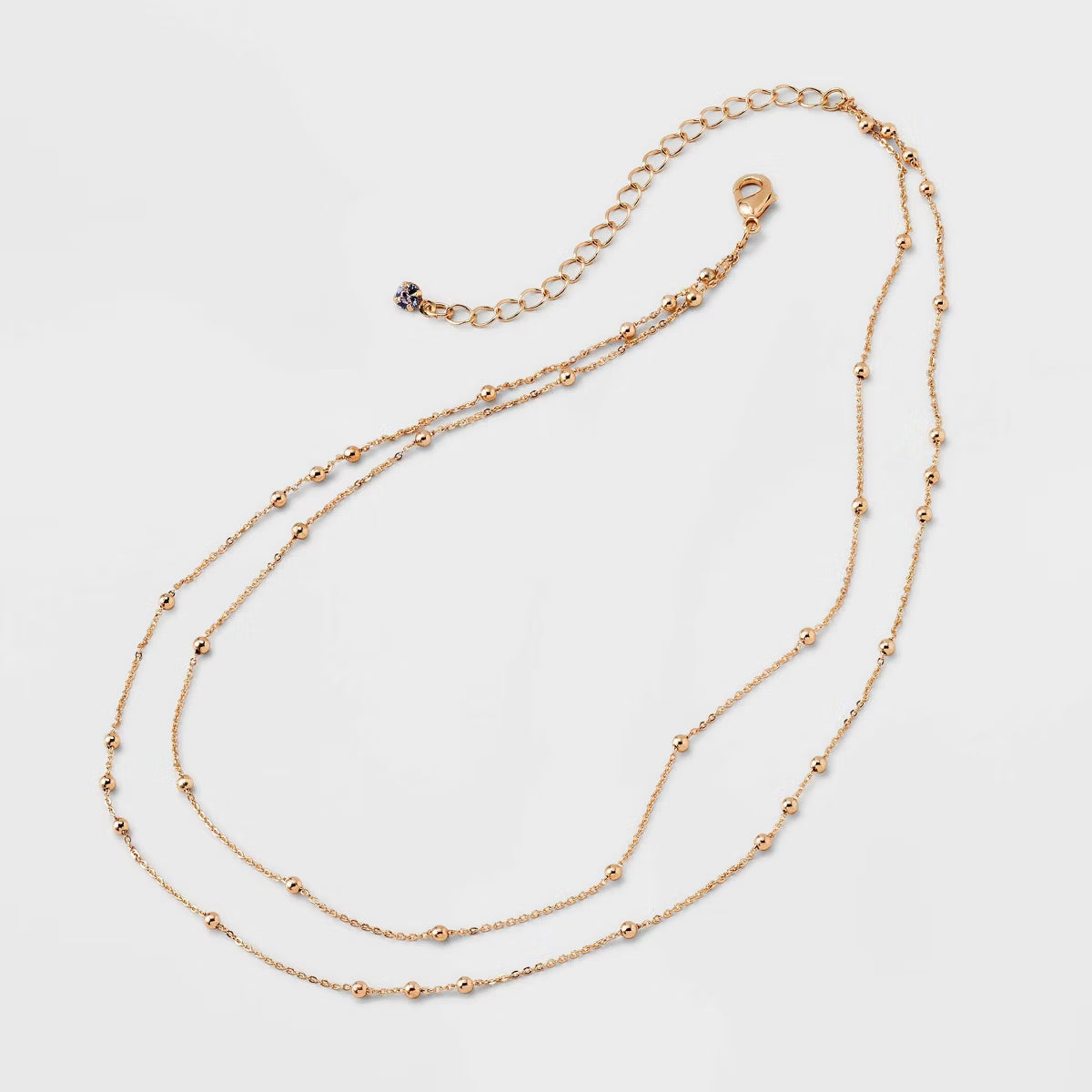 Gold necklace on a light gray background