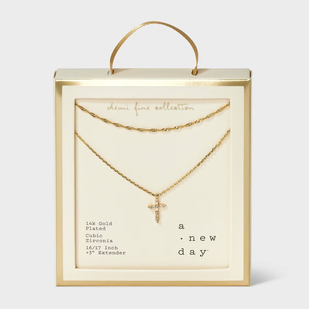 Gold necklace with cross pendant in a 'Dune Fine Collection' box on a white background