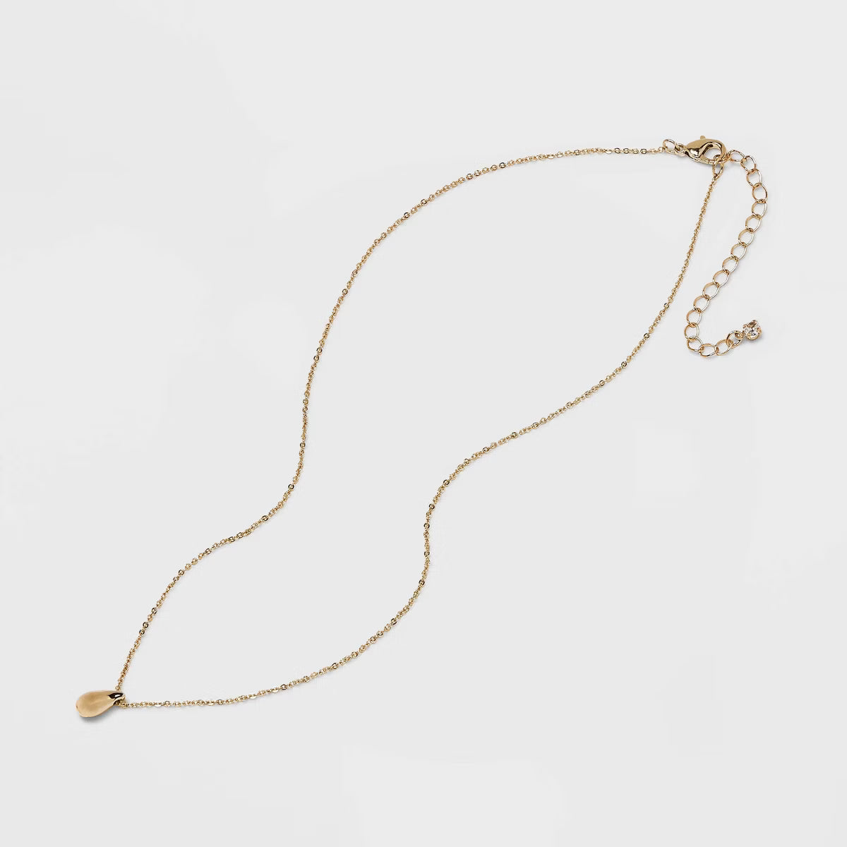 Gold necklace on a light gray background