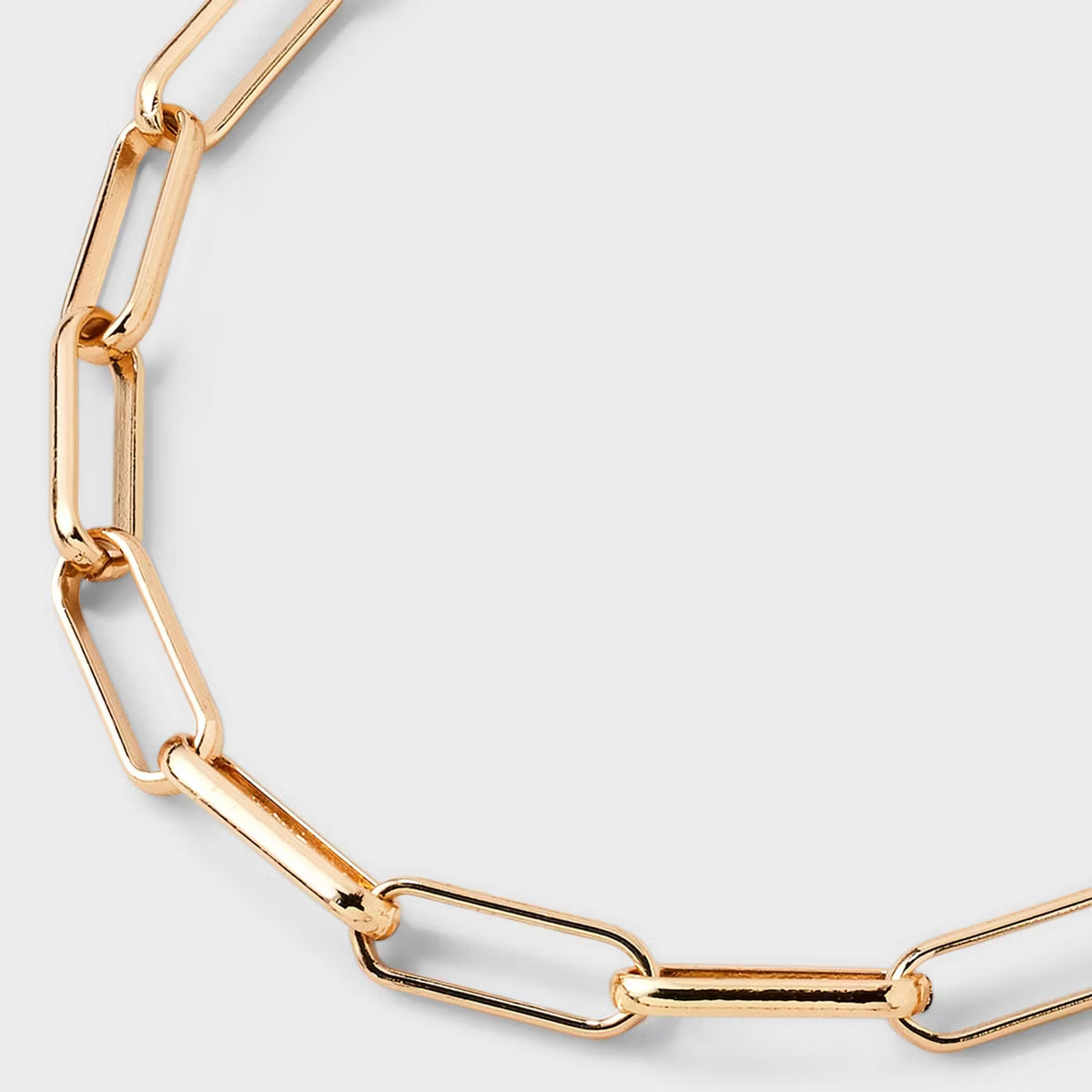 Gold chain necklace on a light gray background