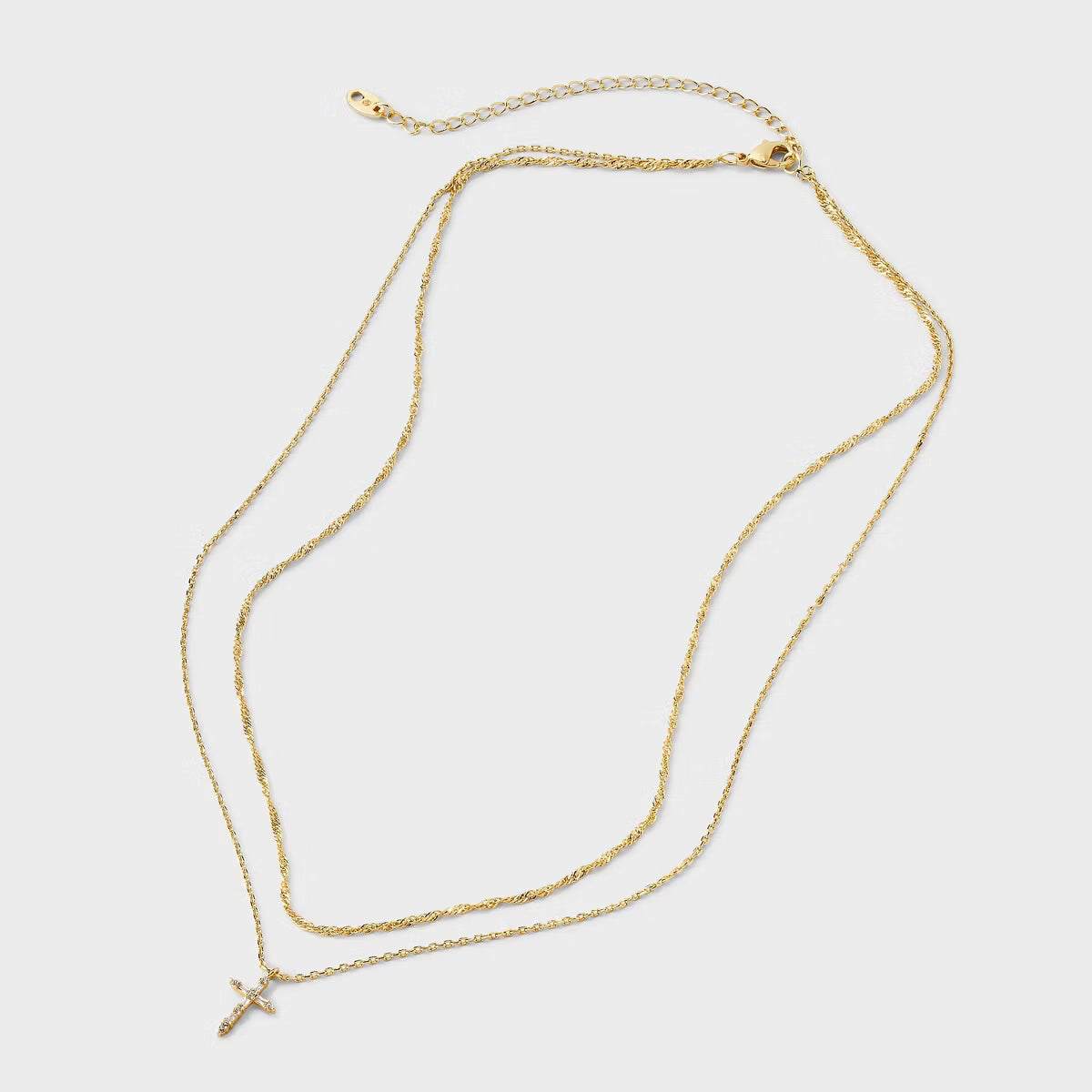 Gold necklace on a light gray background