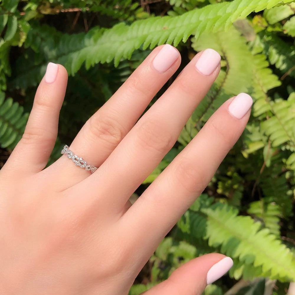 Hand with a ring on a background of green ferns