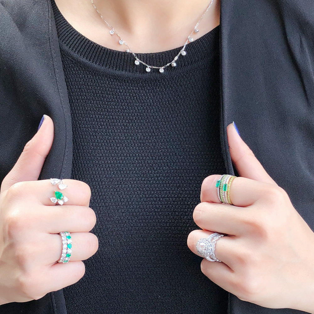 Alternating emerald and diamond eternity band stacked with other rings