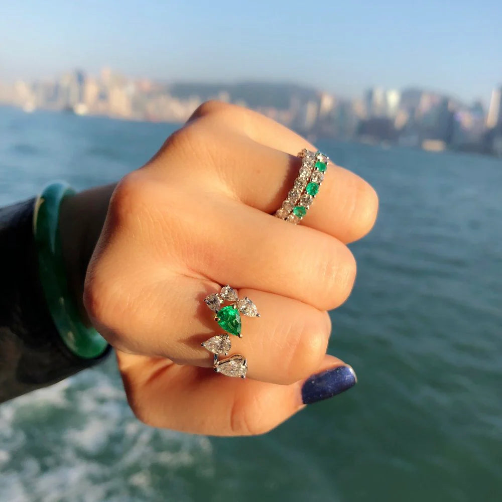 Alternating emerald and diamond eternity band stacked with other rings
