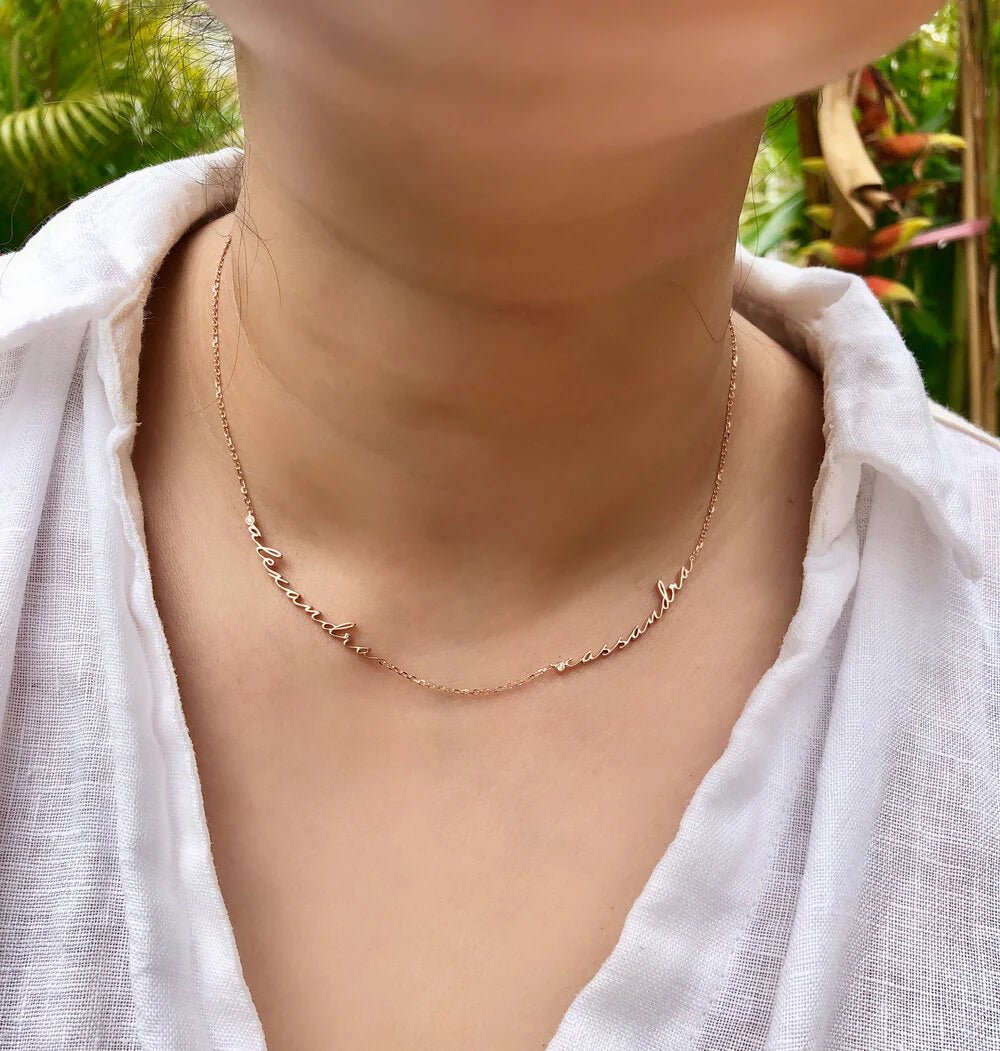 Person wearing a delicate gold necklace with a blurred natural background