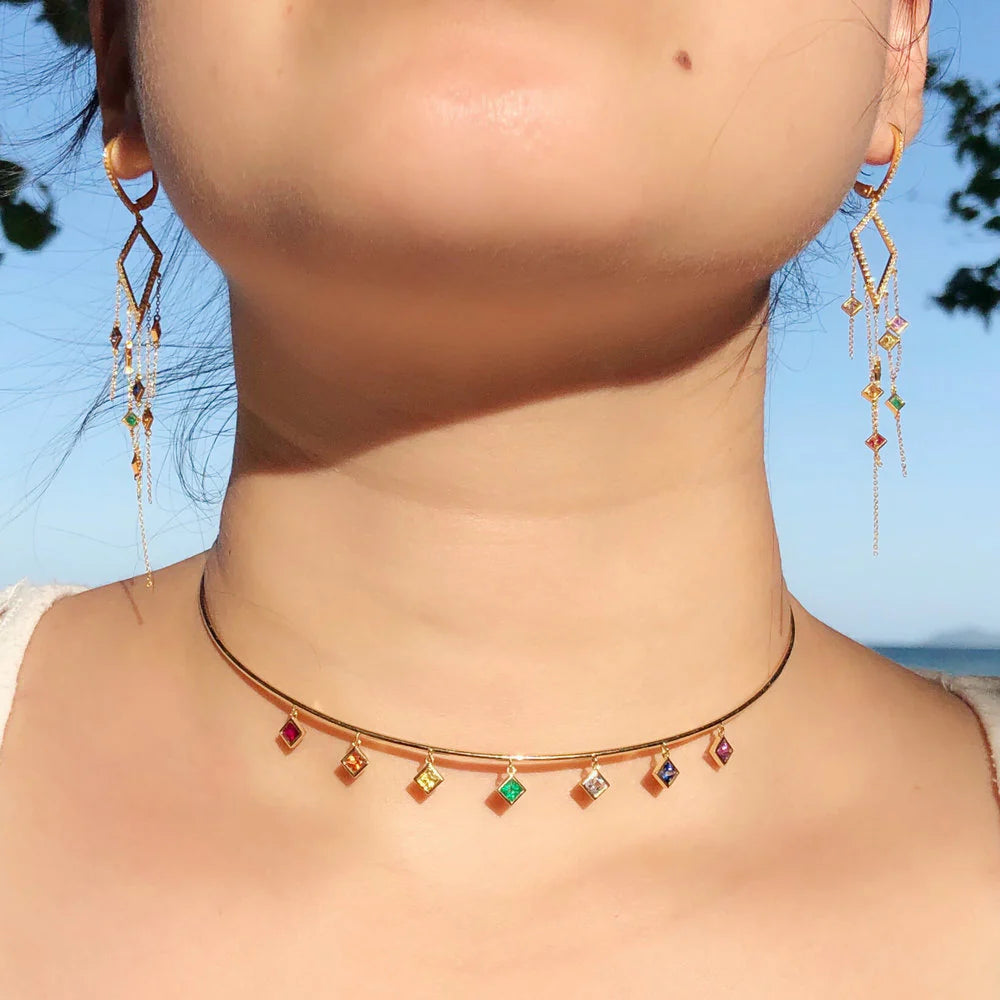 Necklace with colorful pendants worn by a person against a blue sky background