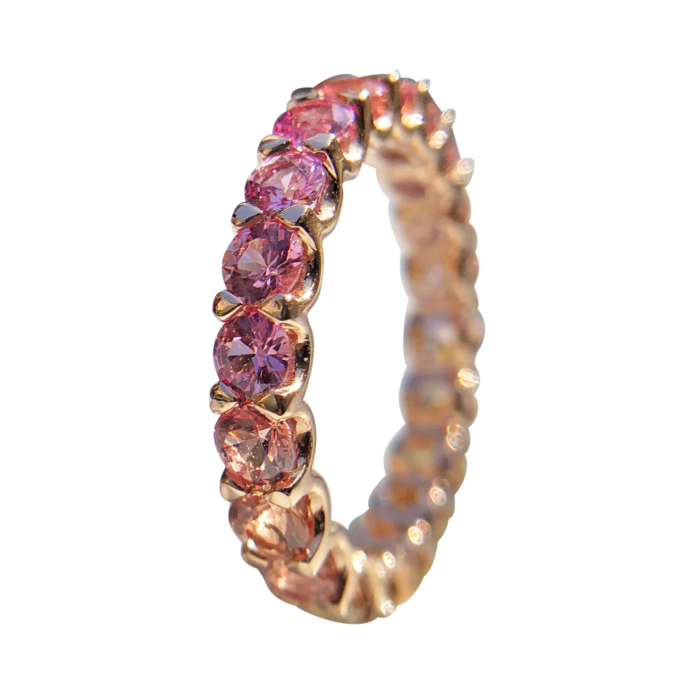 Rose gold ring with pink gemstones on a white background