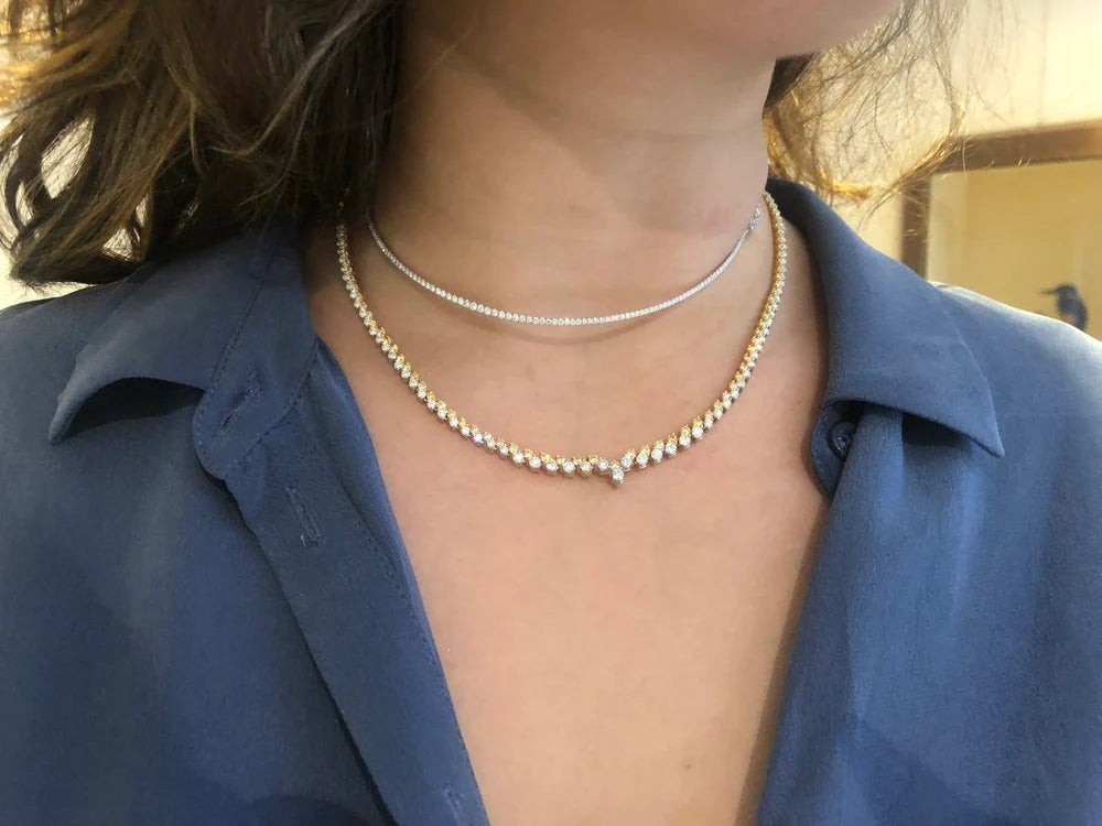 Close-up of a person wearing a pearl necklace with a blurred background