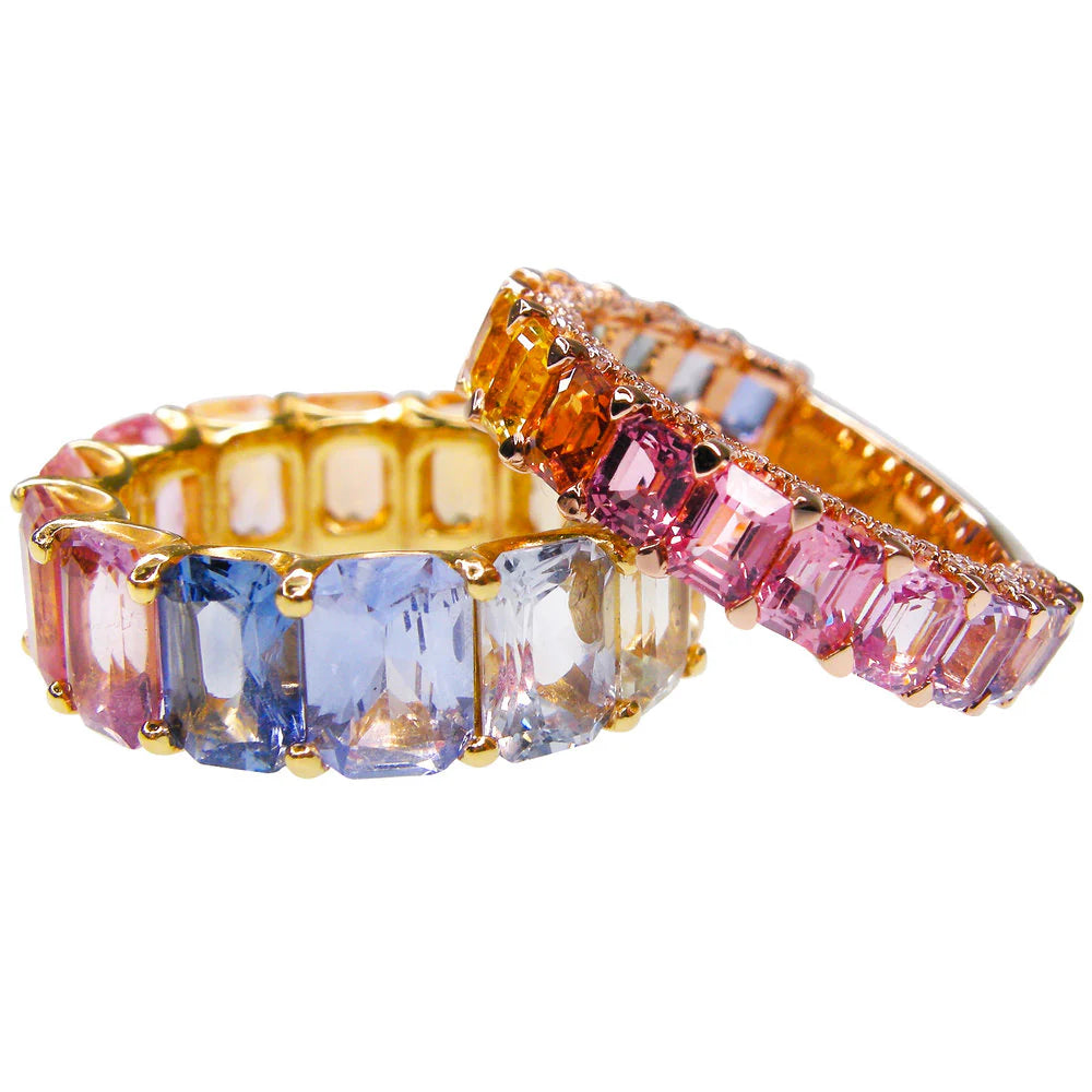 Set of colorful gemstone eternity rings on a white background