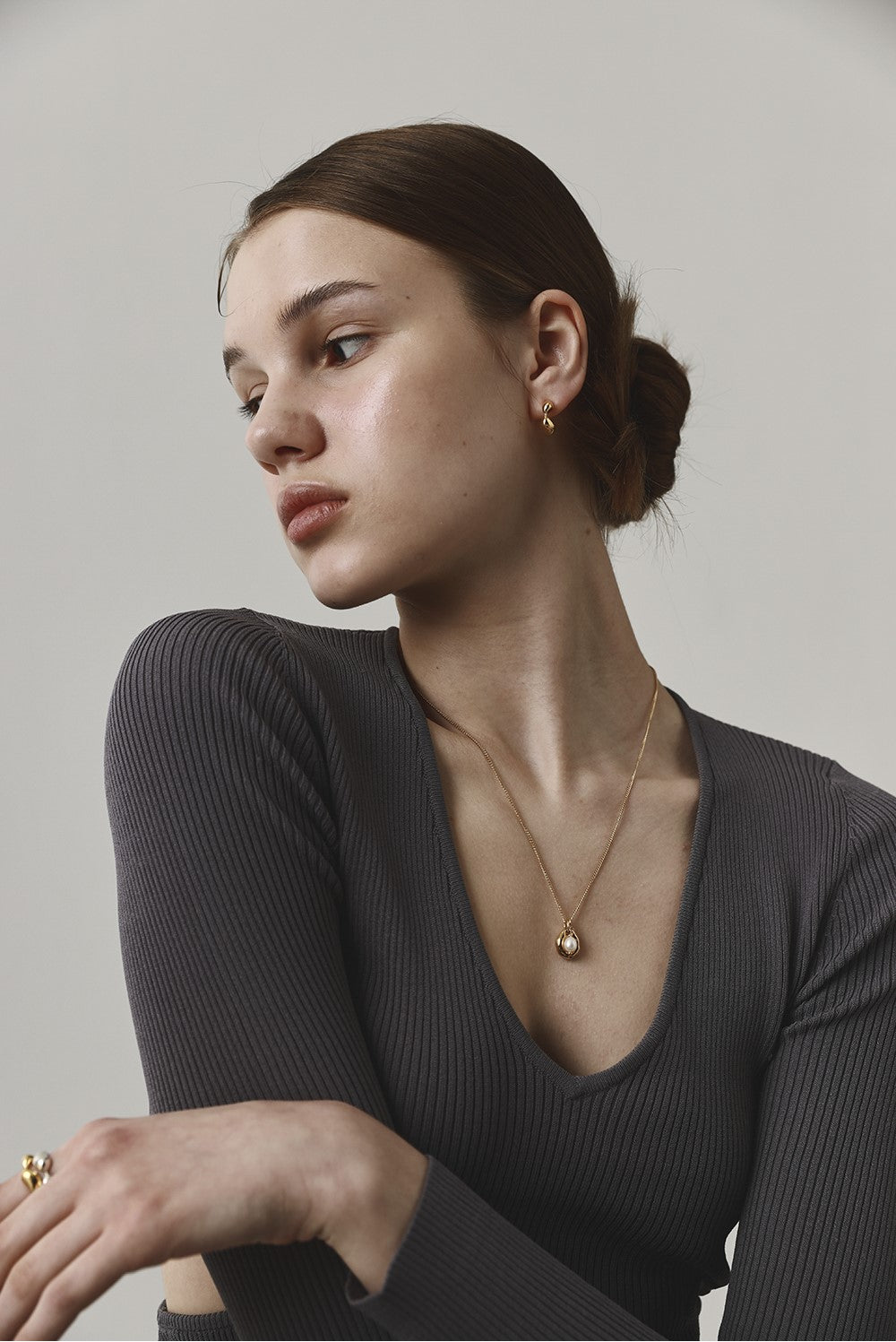 Woman wearing a necklace against a plain background