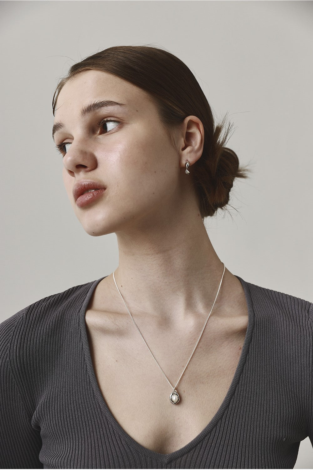 Woman wearing a necklace with a neutral background